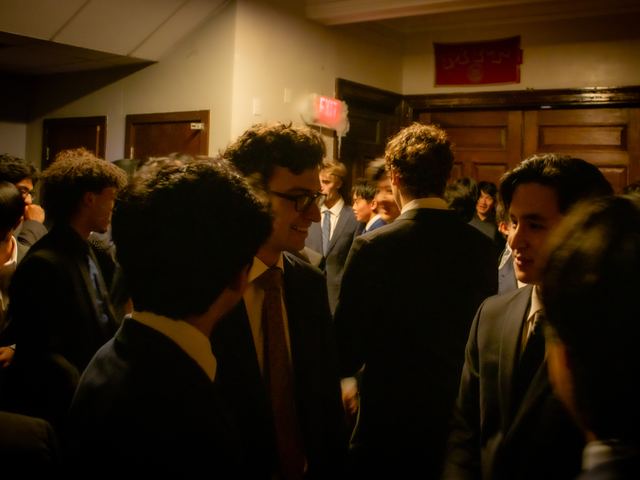 A crowd talking together at a formal event