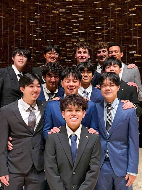 Brothers in suits smiling together for a group portrait