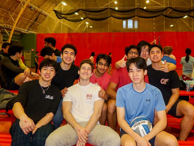 A large group of brothers together after playing volleyball
