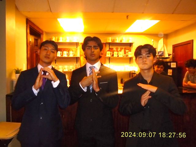 Three brothers in suits posing inside the house