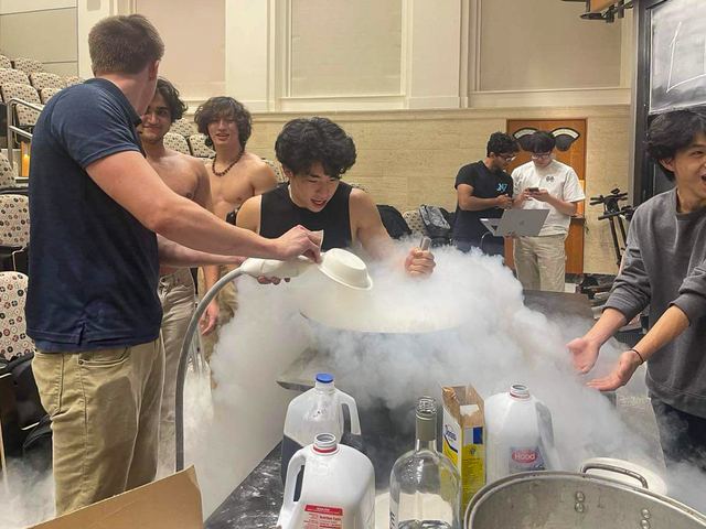 Brothers gathered around a cloud of liquid nitrogen during a demonstration