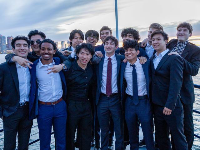 Brothers dressed in suits posing together beside the water