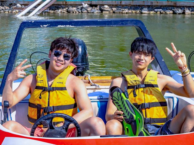 Two brothers wearing life jackets on a boat