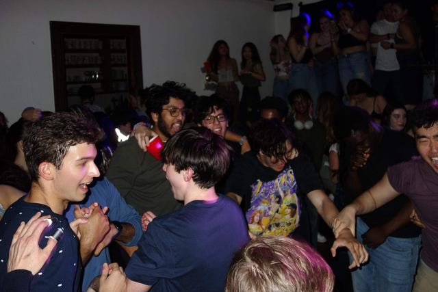 Brothers dancing together at a crowded party