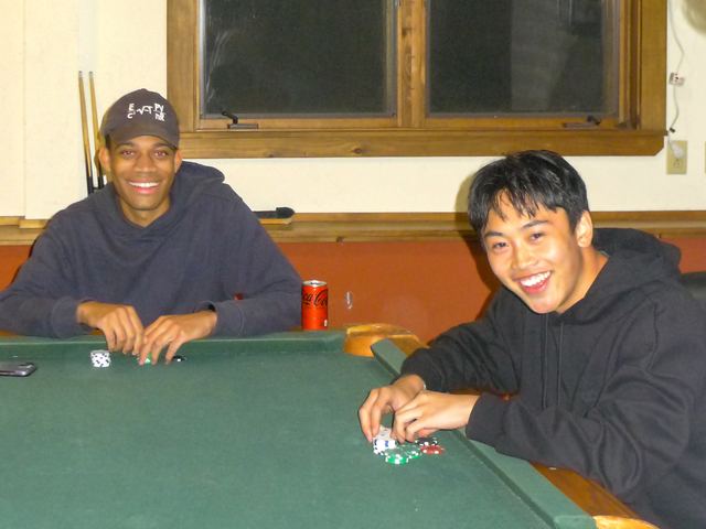 Two brothers playing cards at a green table